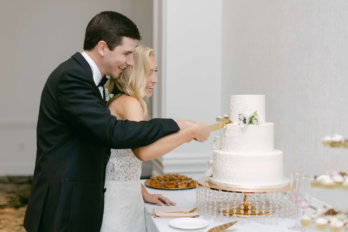A bride and groom cut their cake.