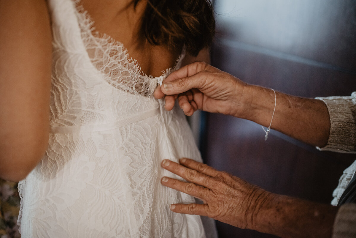 Photographers Jackson Hole capture woman zipping up wedding dress on bride