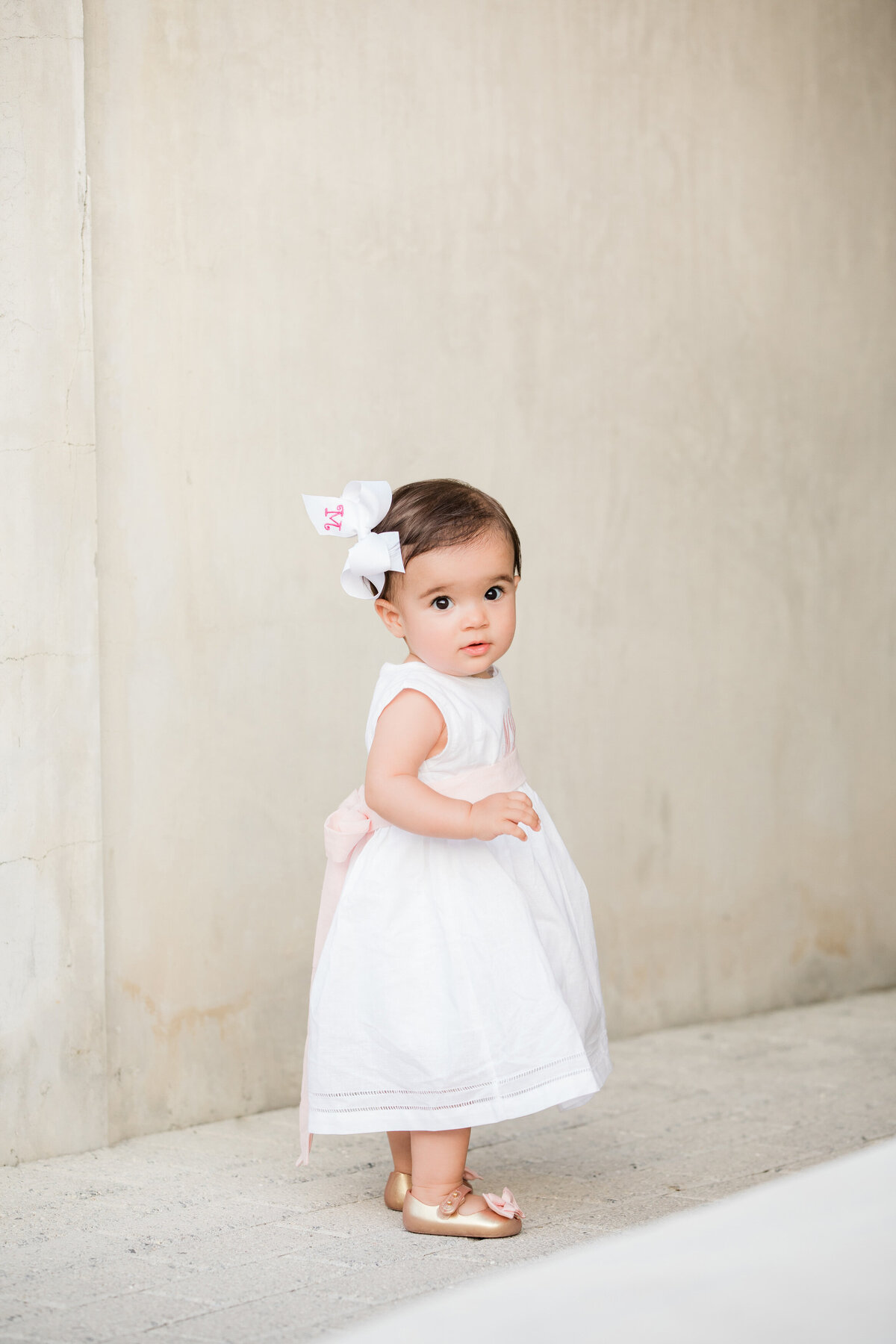A small baby in a white dress