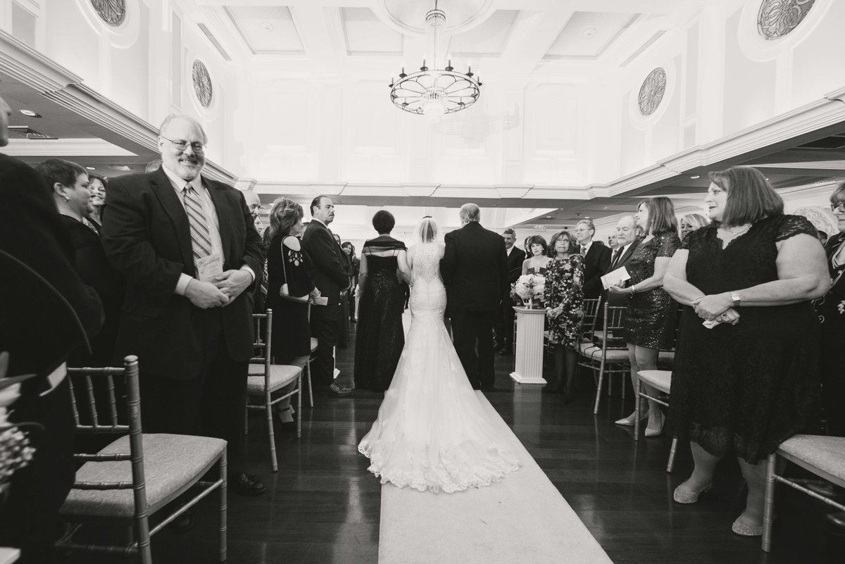 Bride walking down the aisle with her parents at Watermill Caterers