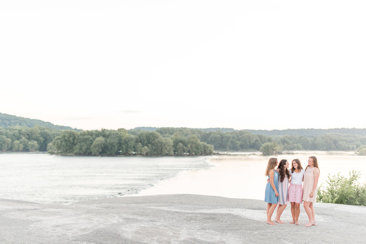 Four Senior girls standing close on right side of photo on large rock at White Cliffs of Canoy.