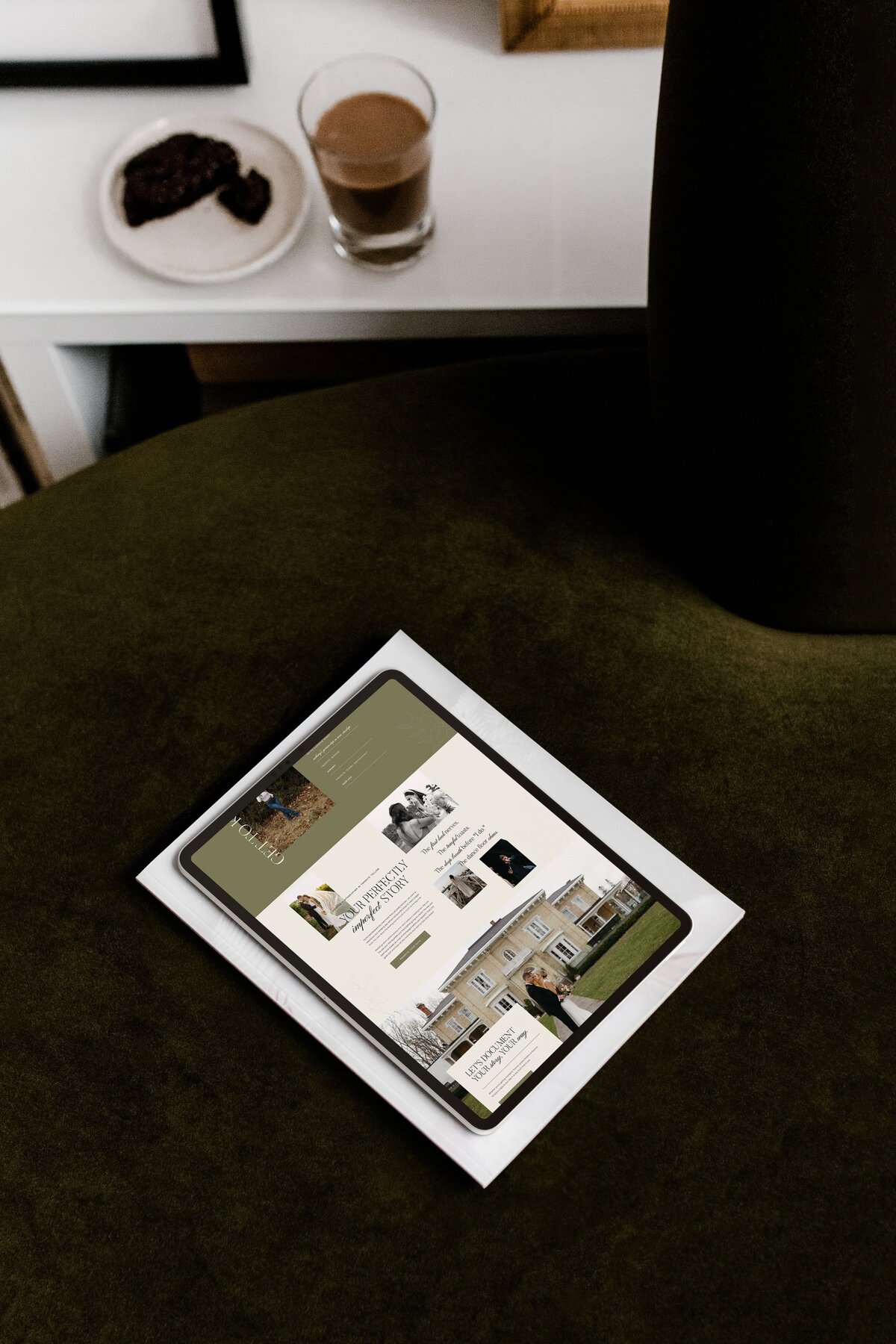 A tablet displaying a website with images of people and text rests on a white surface against a dark background, showcasing showit web design for luxury photographers.