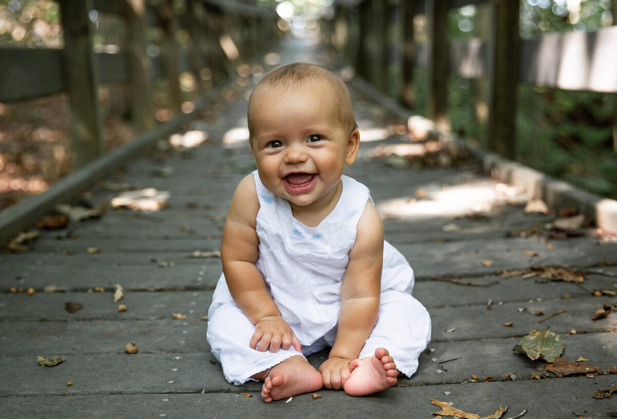 A 6 month old baby girl smiles during her milestone photos in Harford County, Maryland