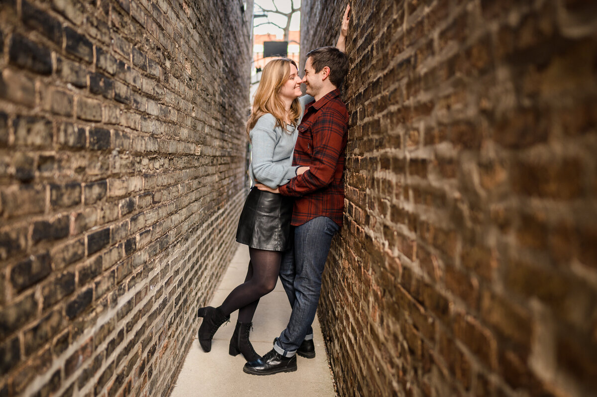 Couple leans against brick wall in Ravenswood