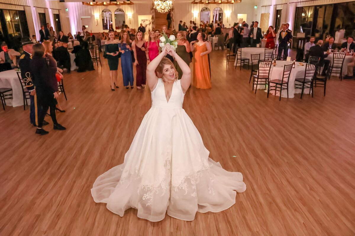 bride in ballgown tosses bouquet at wedding in Texas