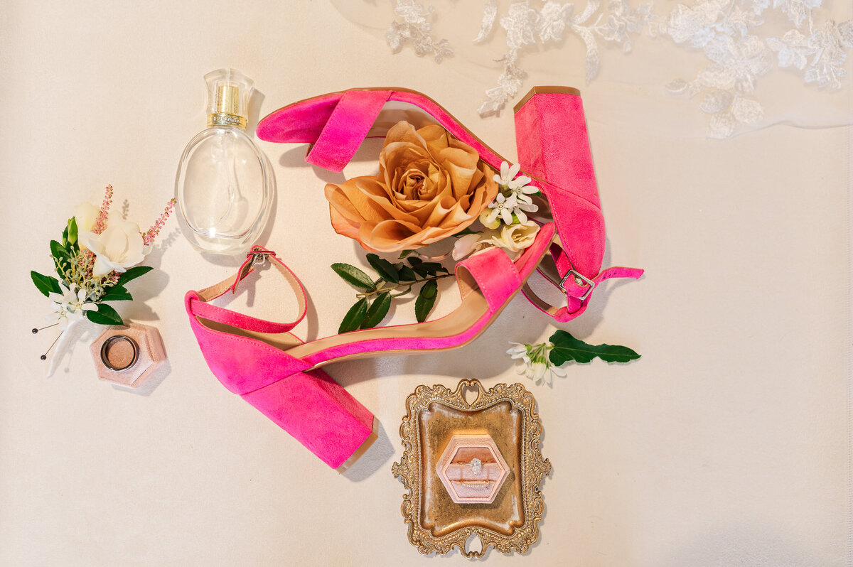 A detail shot of hot pink shoes, flowers, and a gold engagement ring on a wedding day by Raleigh wedding photographer, JoLynn Photography