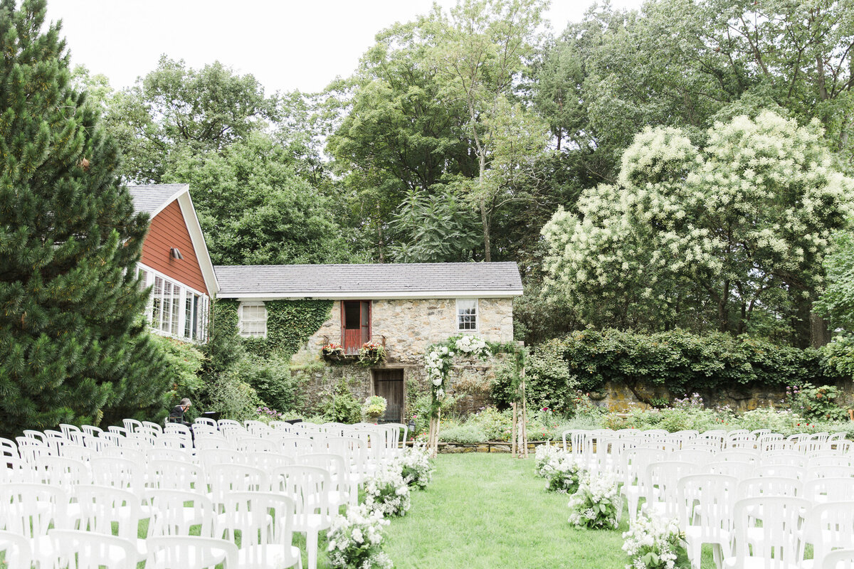 Wedding ceremony set up amidst estate gardens and historic buildings