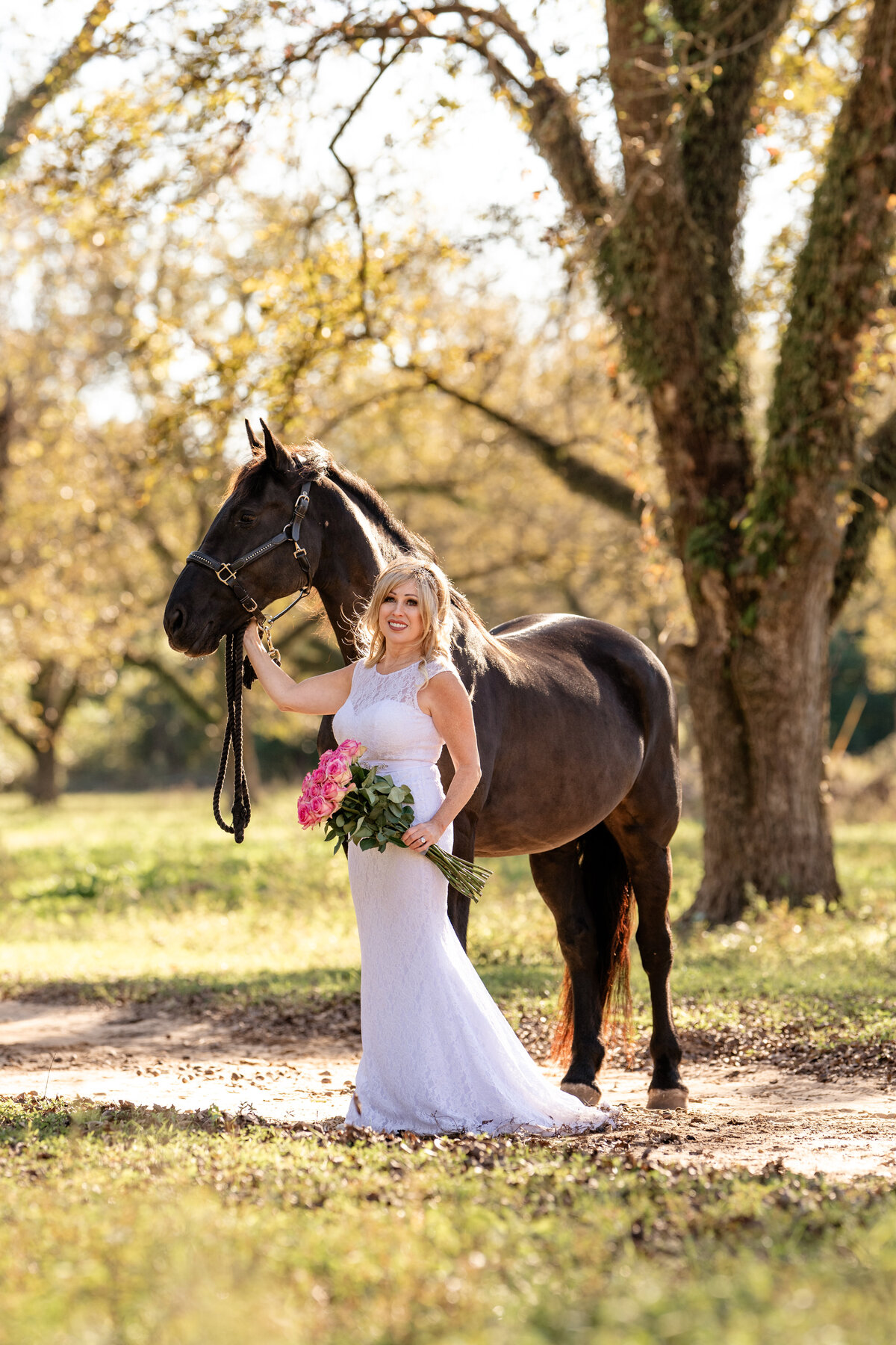 Woman in her wedding dress takes photos with her friesian sporthorse in Georgia.
