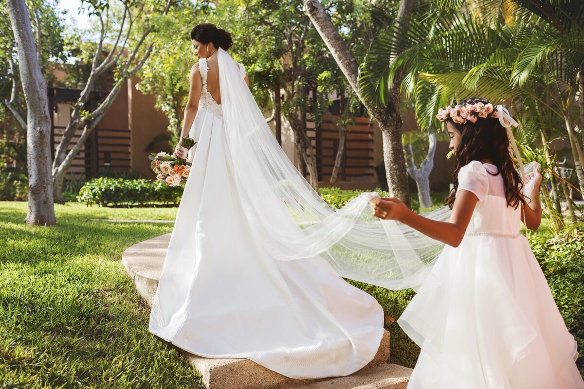 Flower girl helping bride at wedding in Riviera Maya
