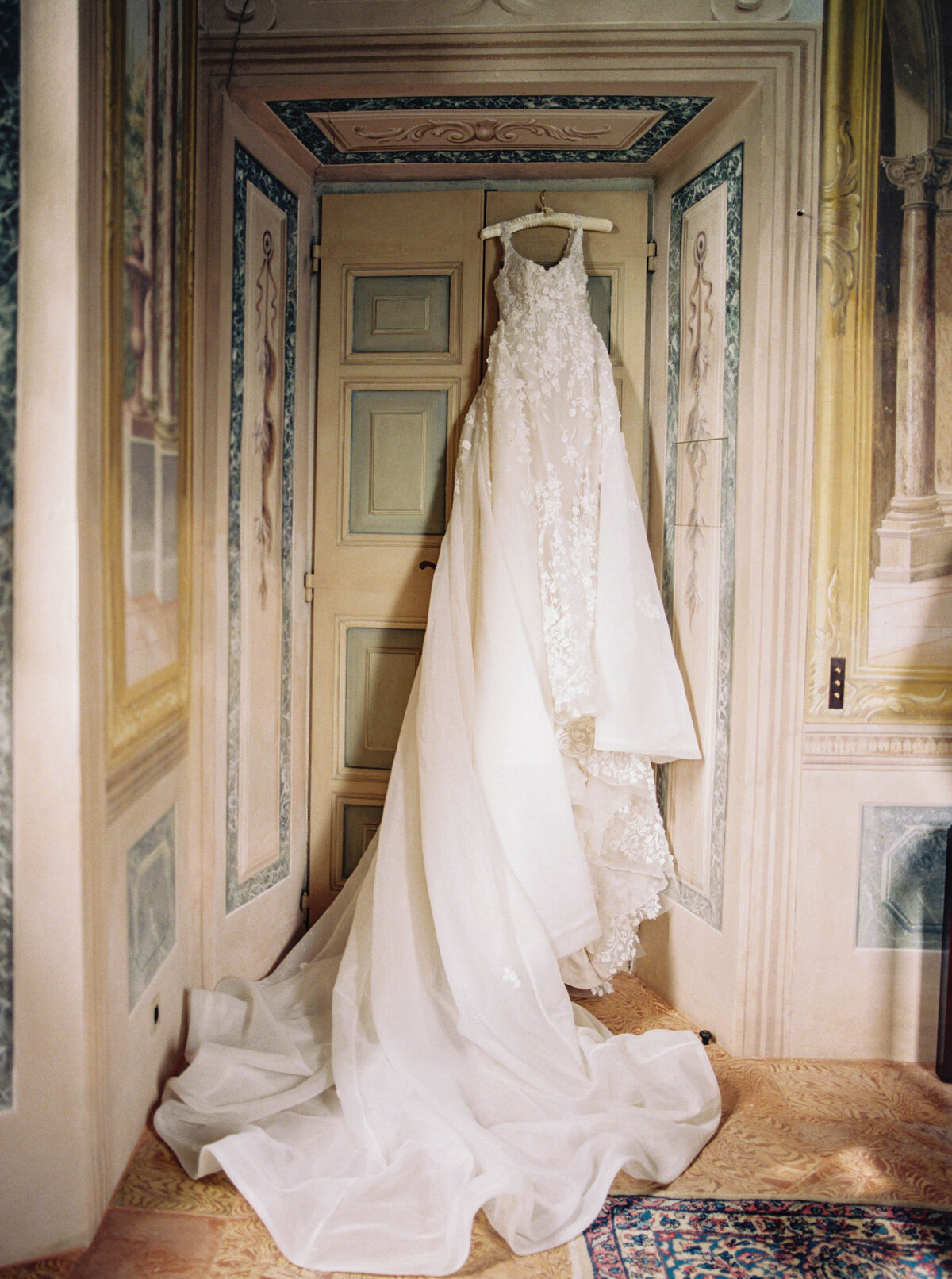 Bride's wedding dress hanging in one of Villa Balbiano's luxurious room