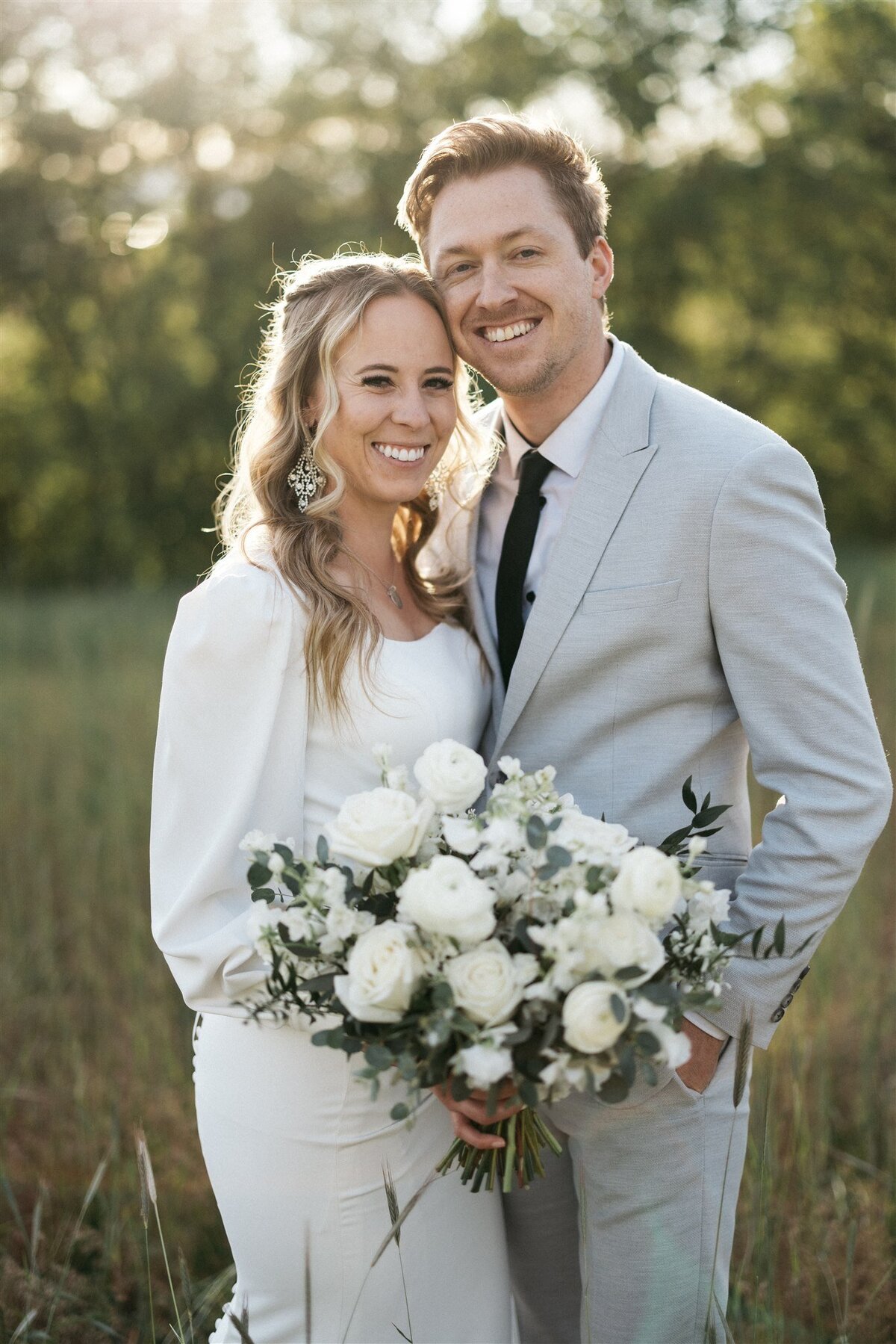 Utah bride and groom with white dress, gray suit, and white bouquet.