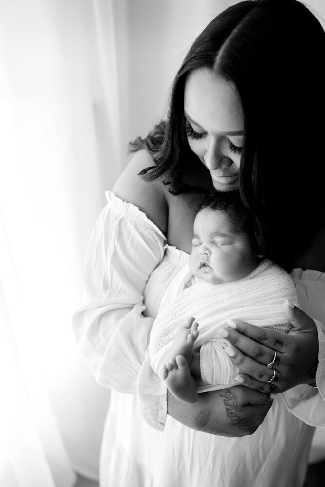 Newborn session of baby boy with mother wearing a dress