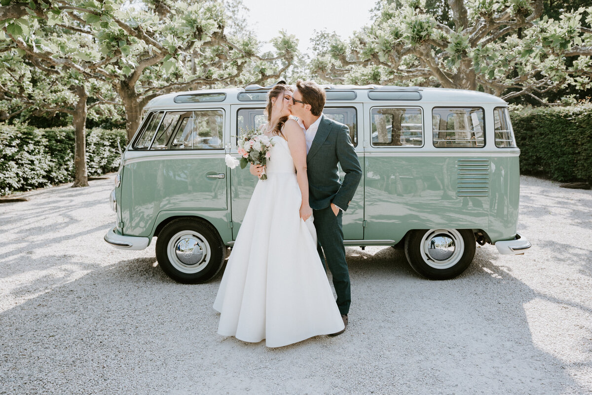 Couple posing with their Volkswagon wedding van