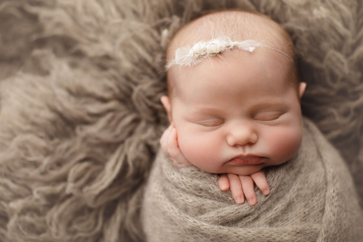 newborn baby girl sleeping with white bow in hair