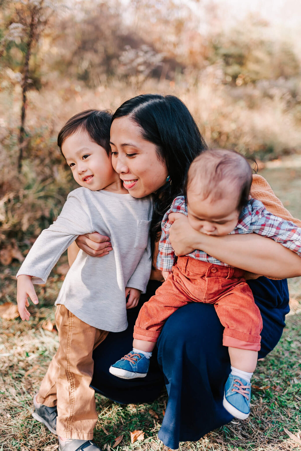 A woman sweetly hugging her sons during their family session in Northern Virginia