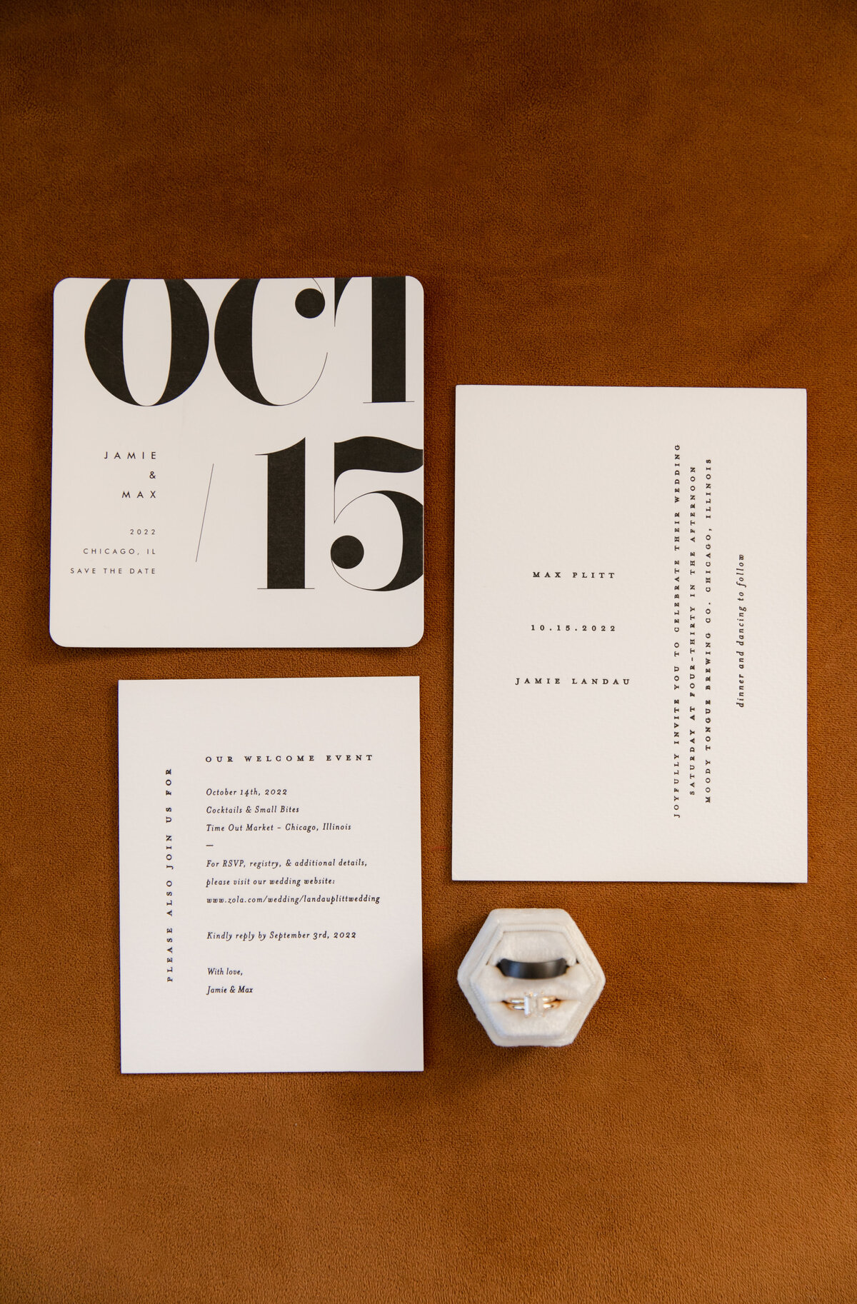 Flatlay displays simple black and white wedding invitations and wedding bands.