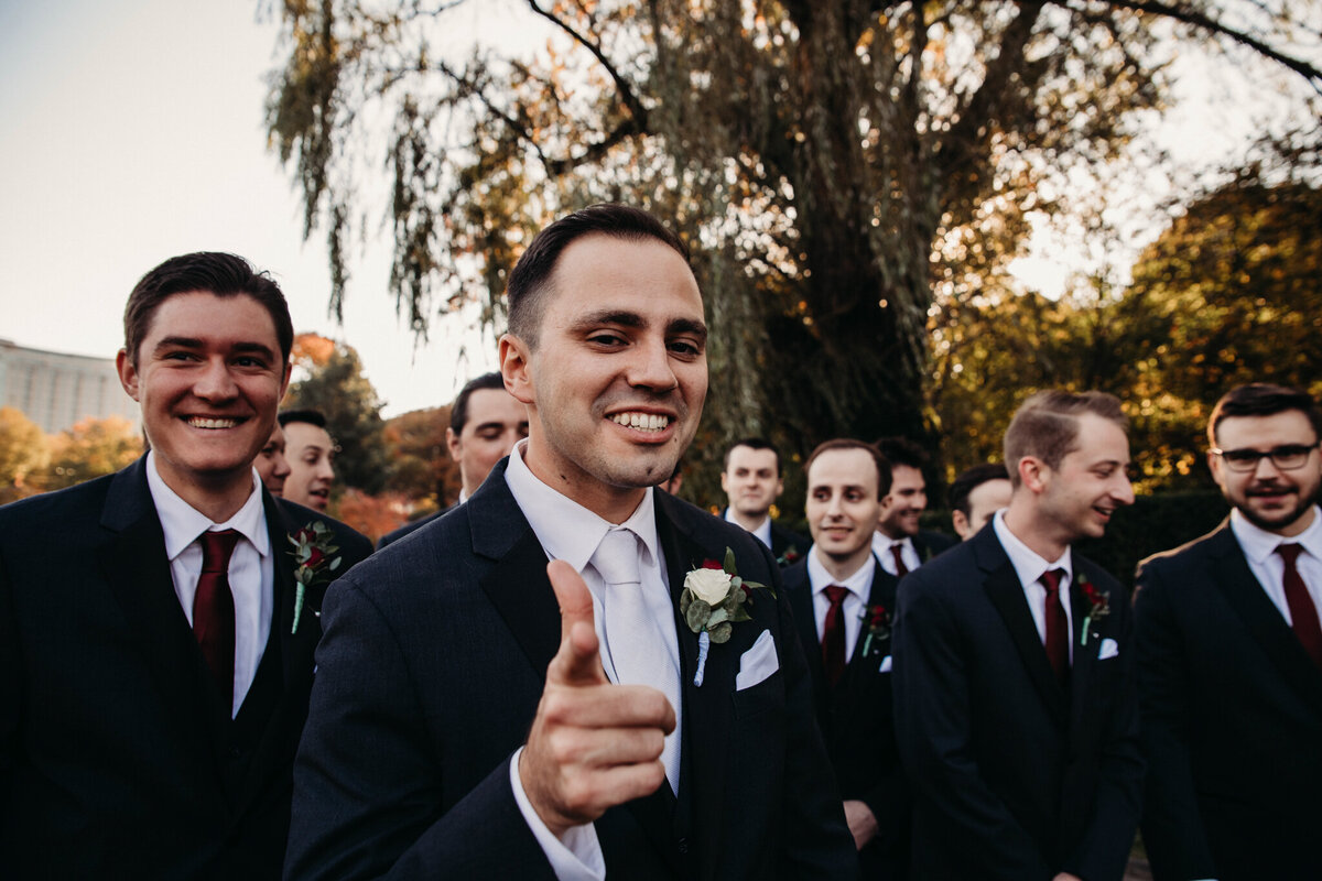 Groomsmen laugh and walk at Clevleand art Museum