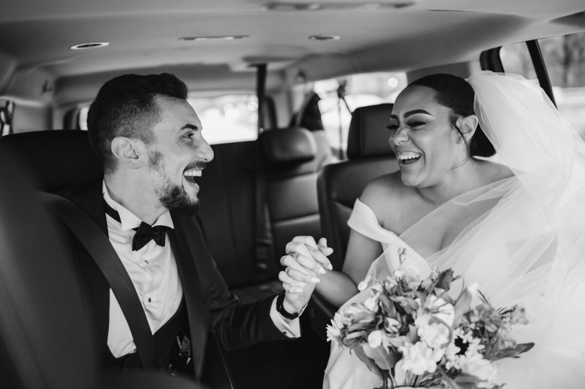 Bride and groom hold hands in a Chicago taxi