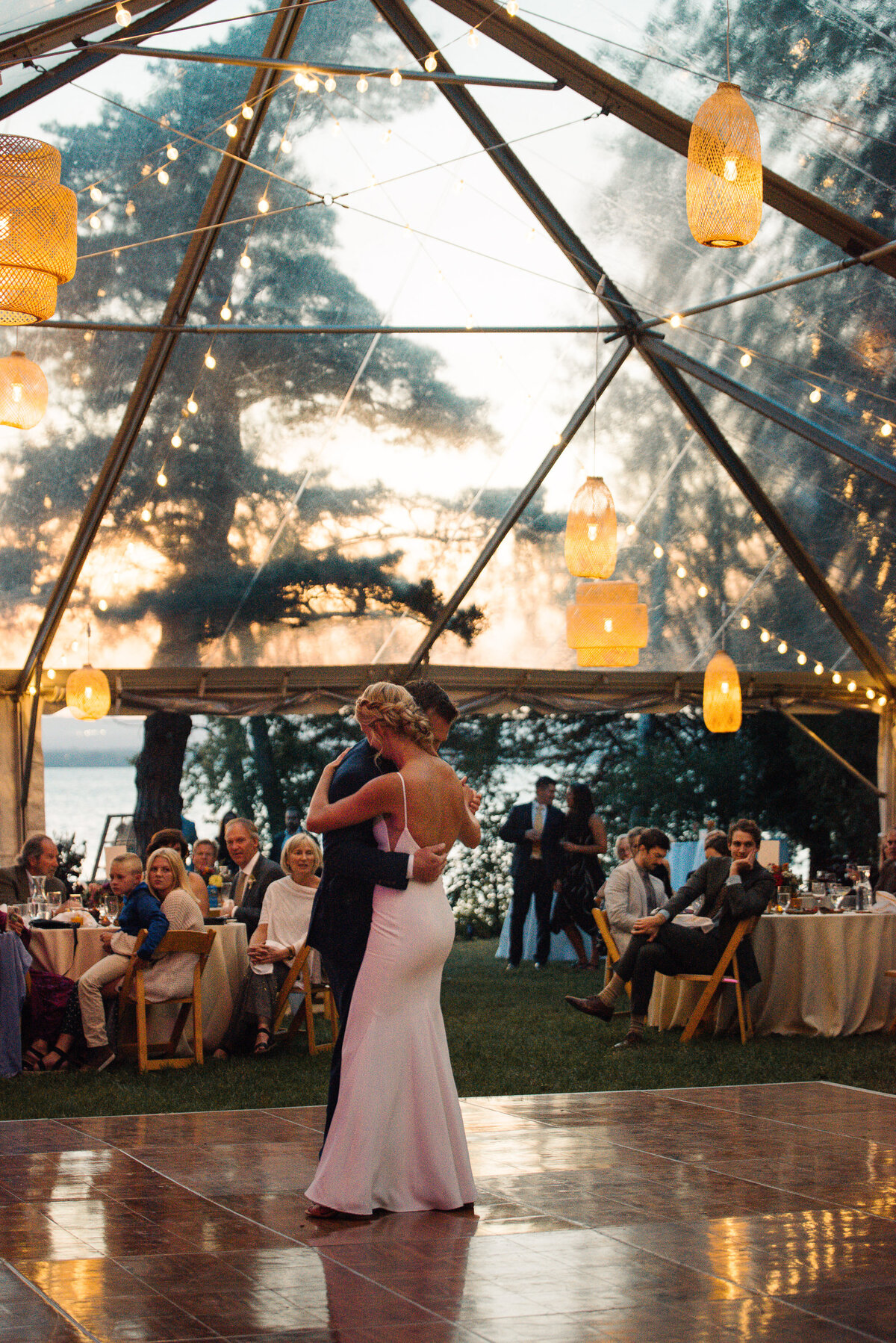 Romantic first dance in cleartop tent at sunset