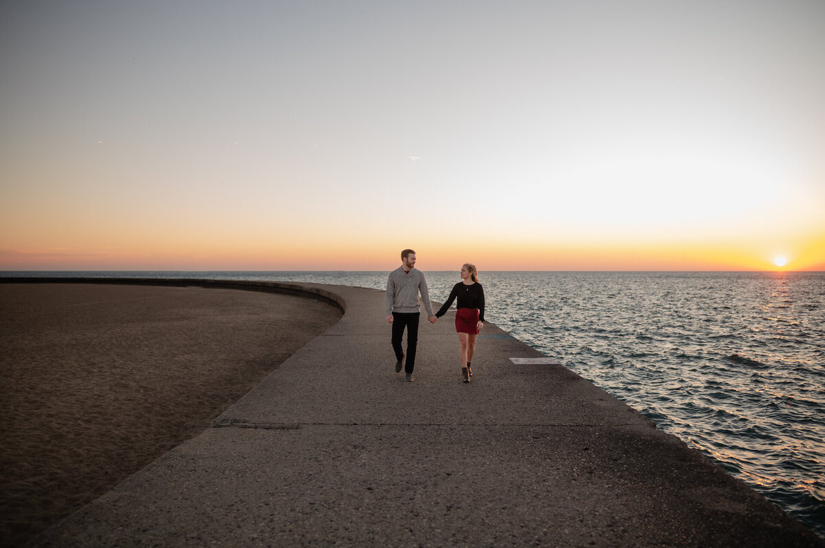 Couple holds hands at North Avenue Beach in Chicago, Illinois