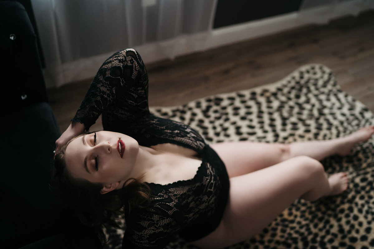 Woman wearing black lingerie laying on cheetah print rug for a Worcester Boudoir Photographer Kerry Callahan Boudoir