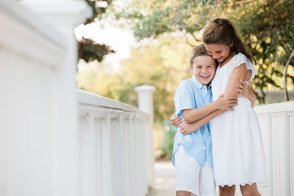 Two siblings hugging and smiling