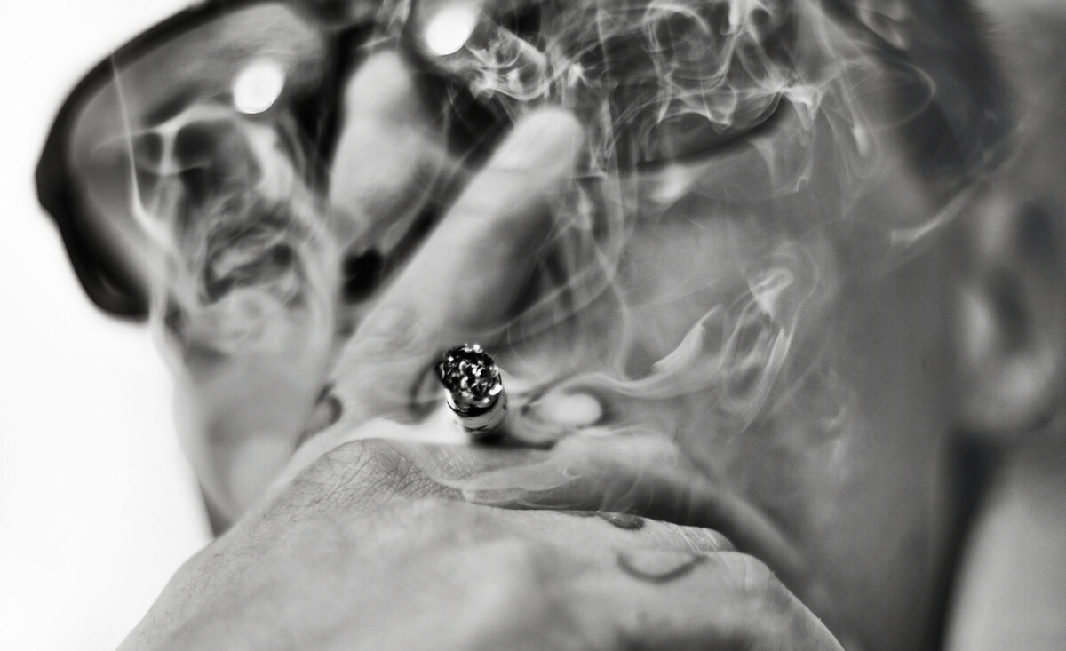 Male musician portrait G black and white close up cigarette smoke rising through fingers wearing sunglasses