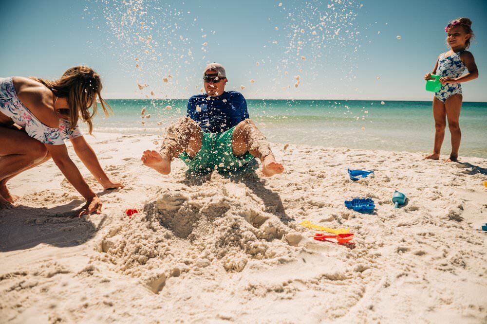 family busting out of the sand at Pensacola Beach, florida