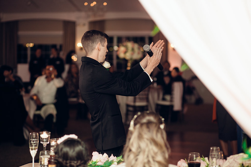Wedding Photograph Of Groom In Black Suit Clapping  His Hands Los Angeles