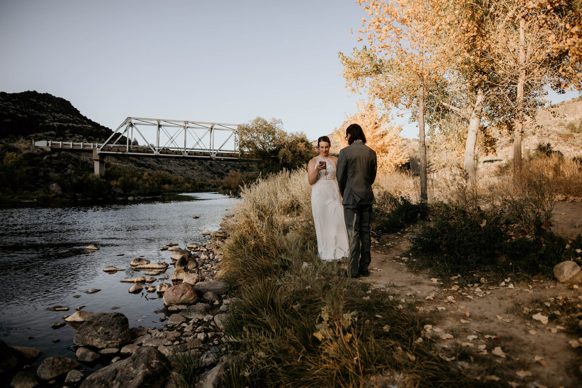 bride and groom exchanging vows by a river