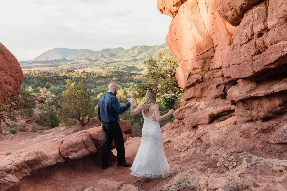 bride and groom holding hands while hiking to elopement destination europe
