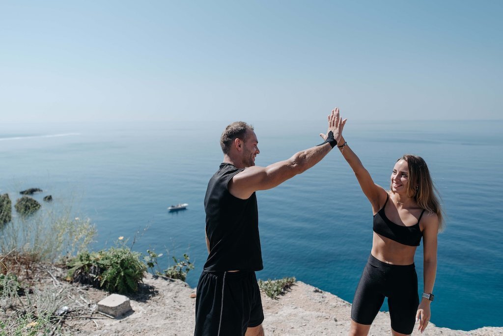 EnForma wellness ambassadors celebrating atop a scenic coastal trail, promoting community, movement, and healthy living through nature-based wellness experiences.