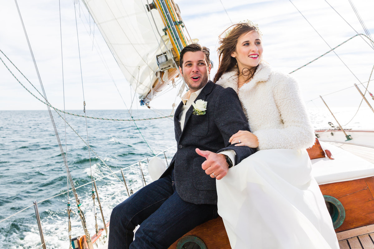 The bride and groom relish in the wind aboard the Silverlining Sailing boat at their Ogunquit Maine elopement