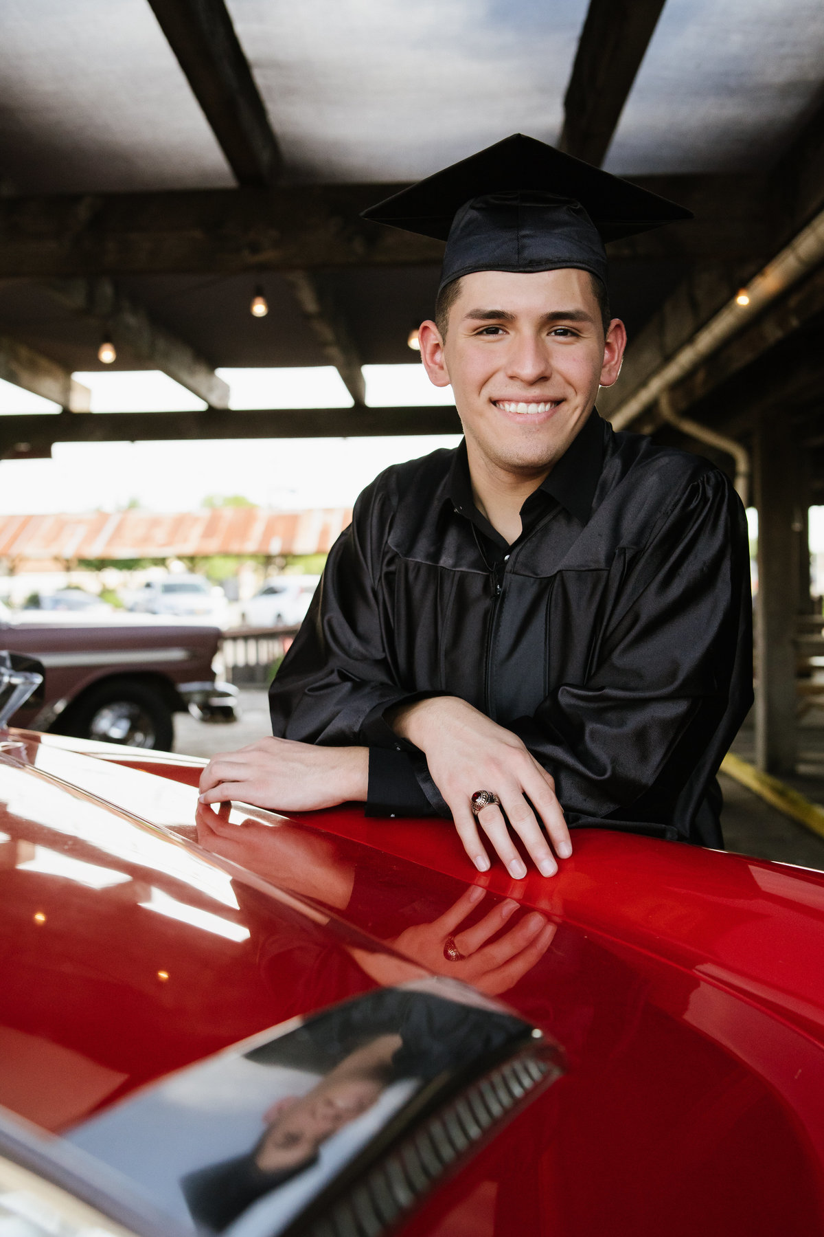 high school senior cap  and gown posing by classic car by San Antonio senior photographer