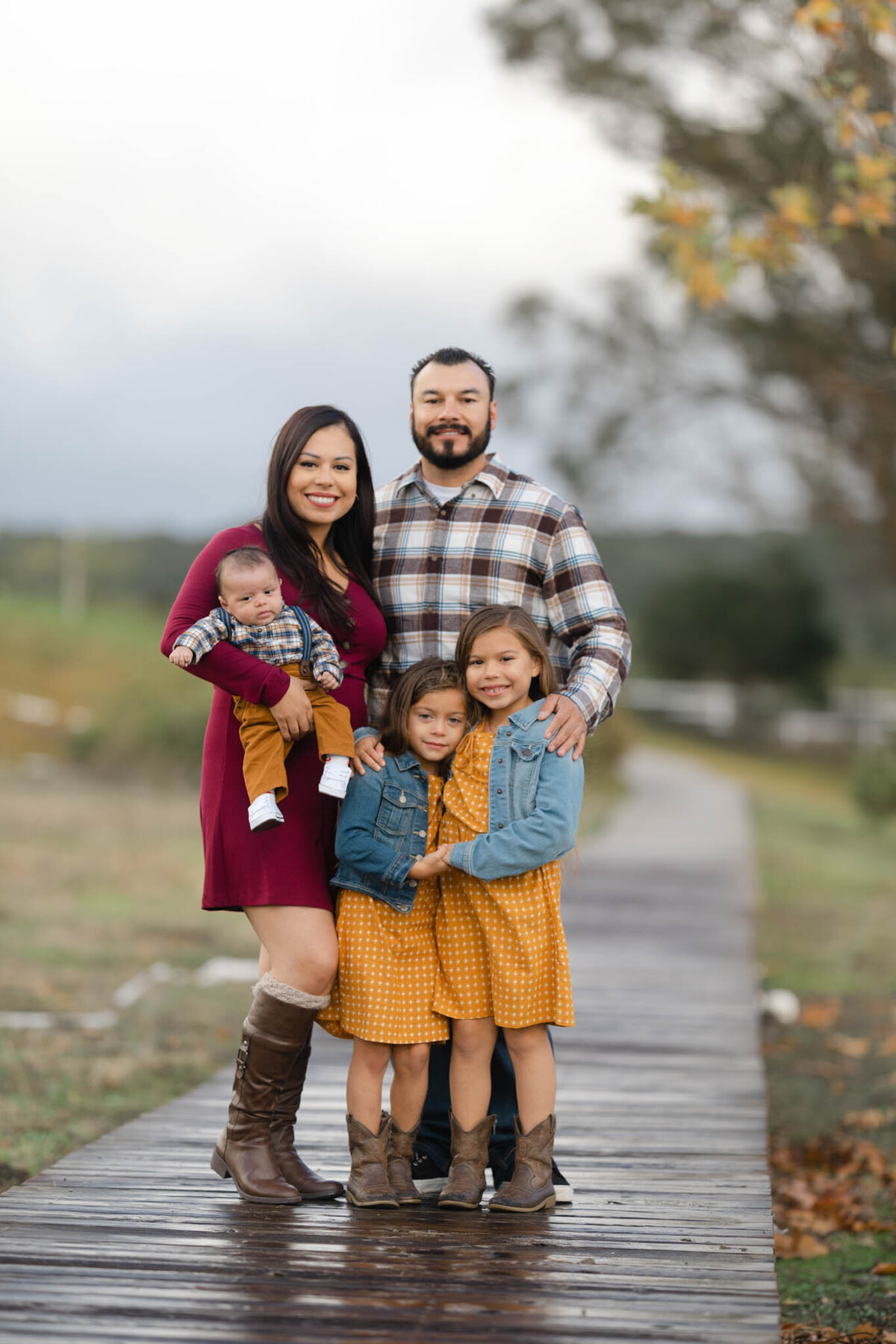 family on bridge in plaid during fall