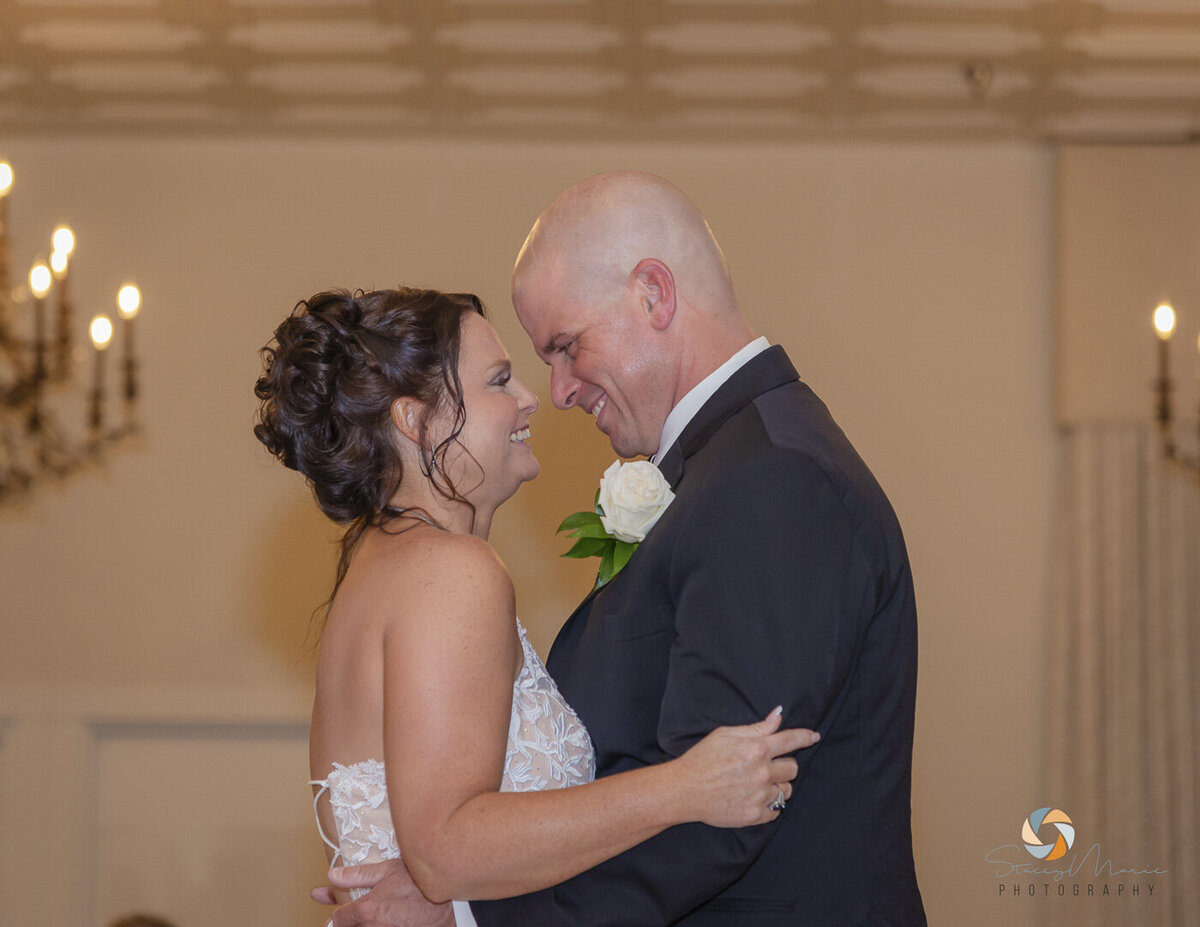 Couple smile and look into each others eyes as they have their first dance.