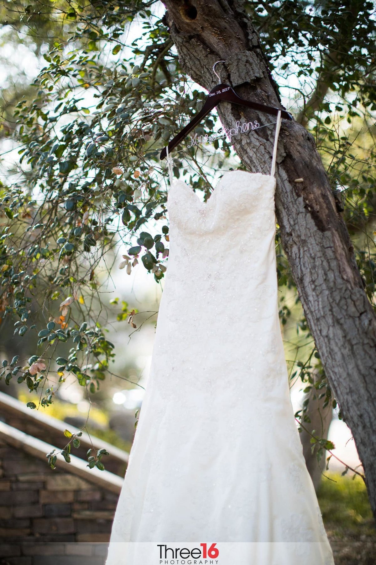 White wedding dress hanging from a tree