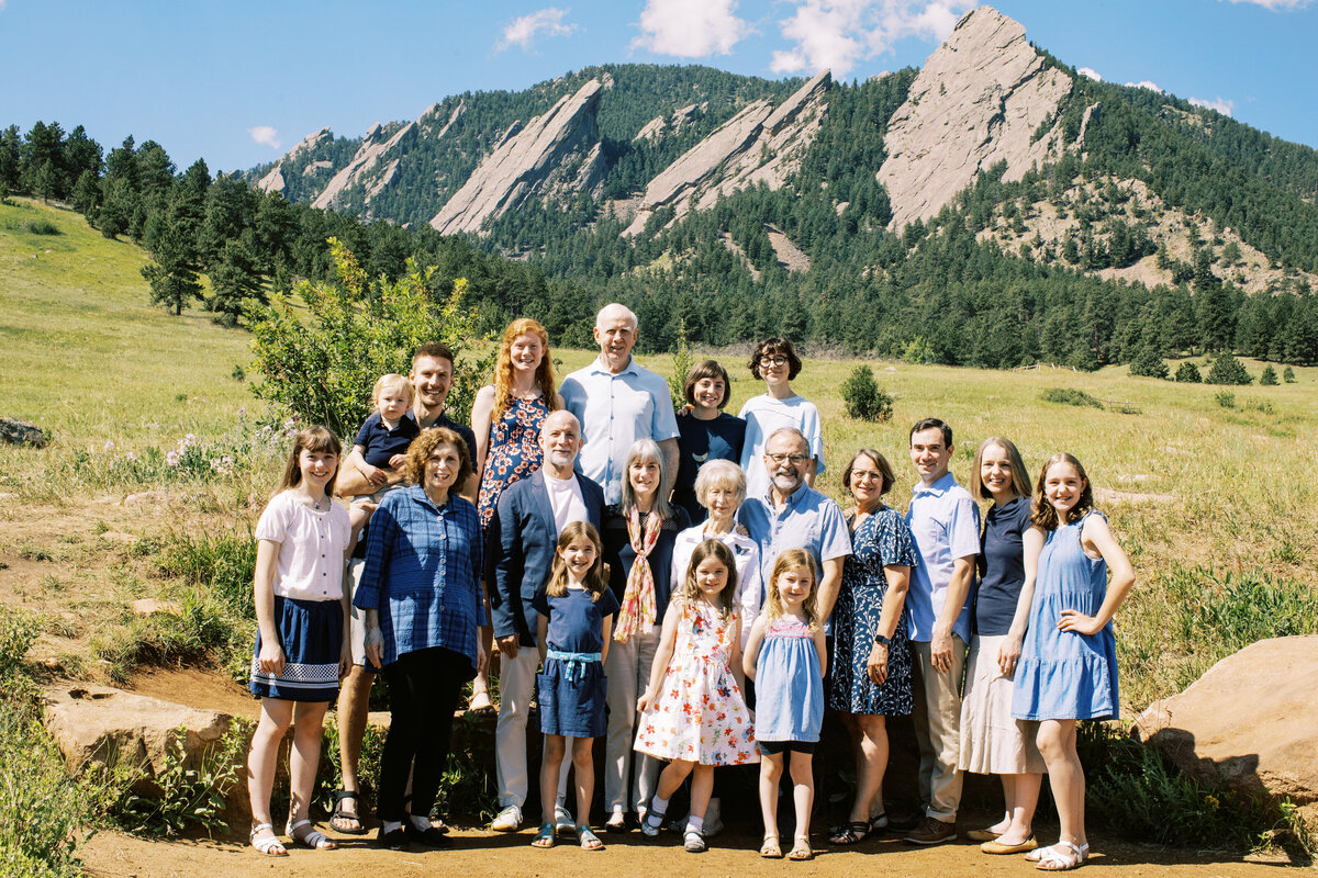 family stands in front of boulder flatirons