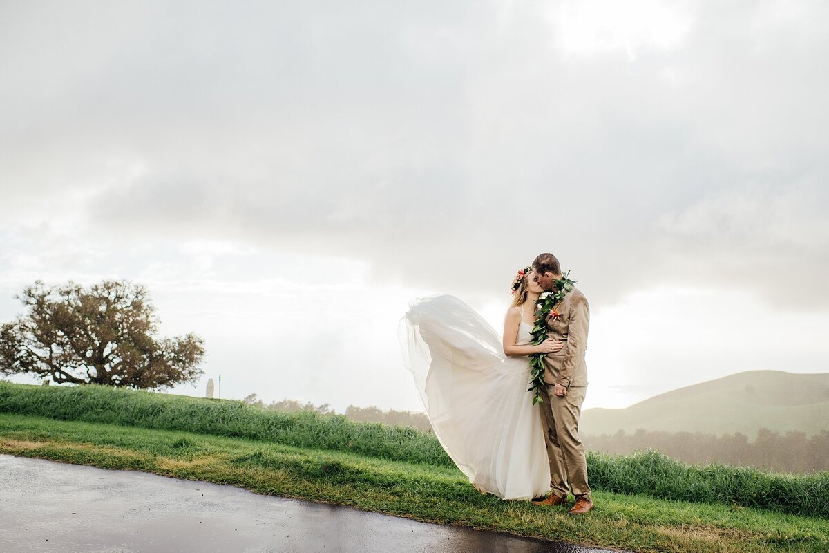 bride and groom kiss in the rain