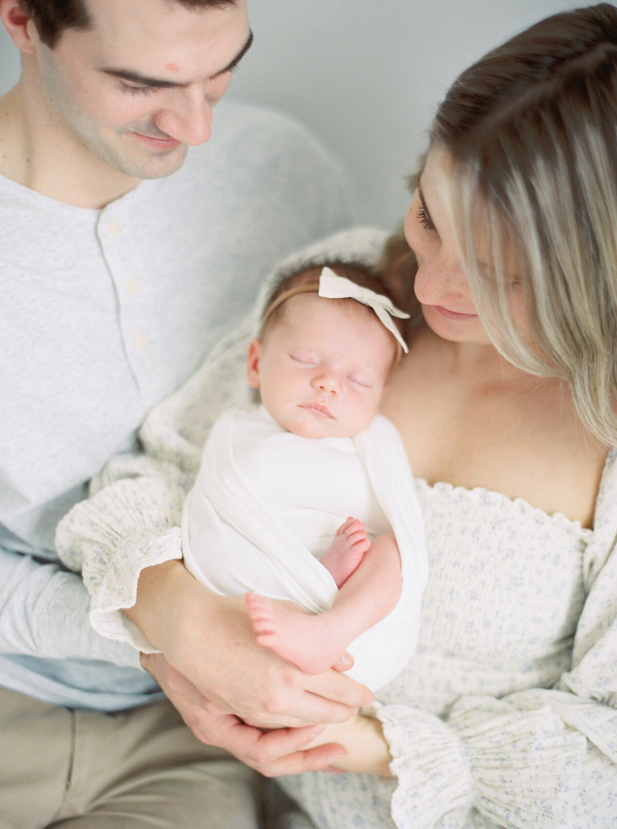 new parents holding newborn baby girl in studio by newborn photography milwaukee wi talia laird photography