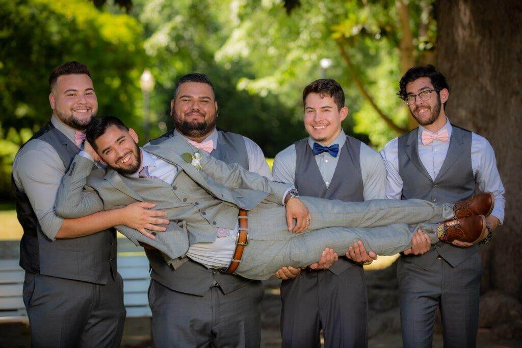 Four groomsmen hold groom as he poses as if comfortable looking at the camera. Photo taken by wedding photographer sacramento, ca, Philippe Studio Pro.