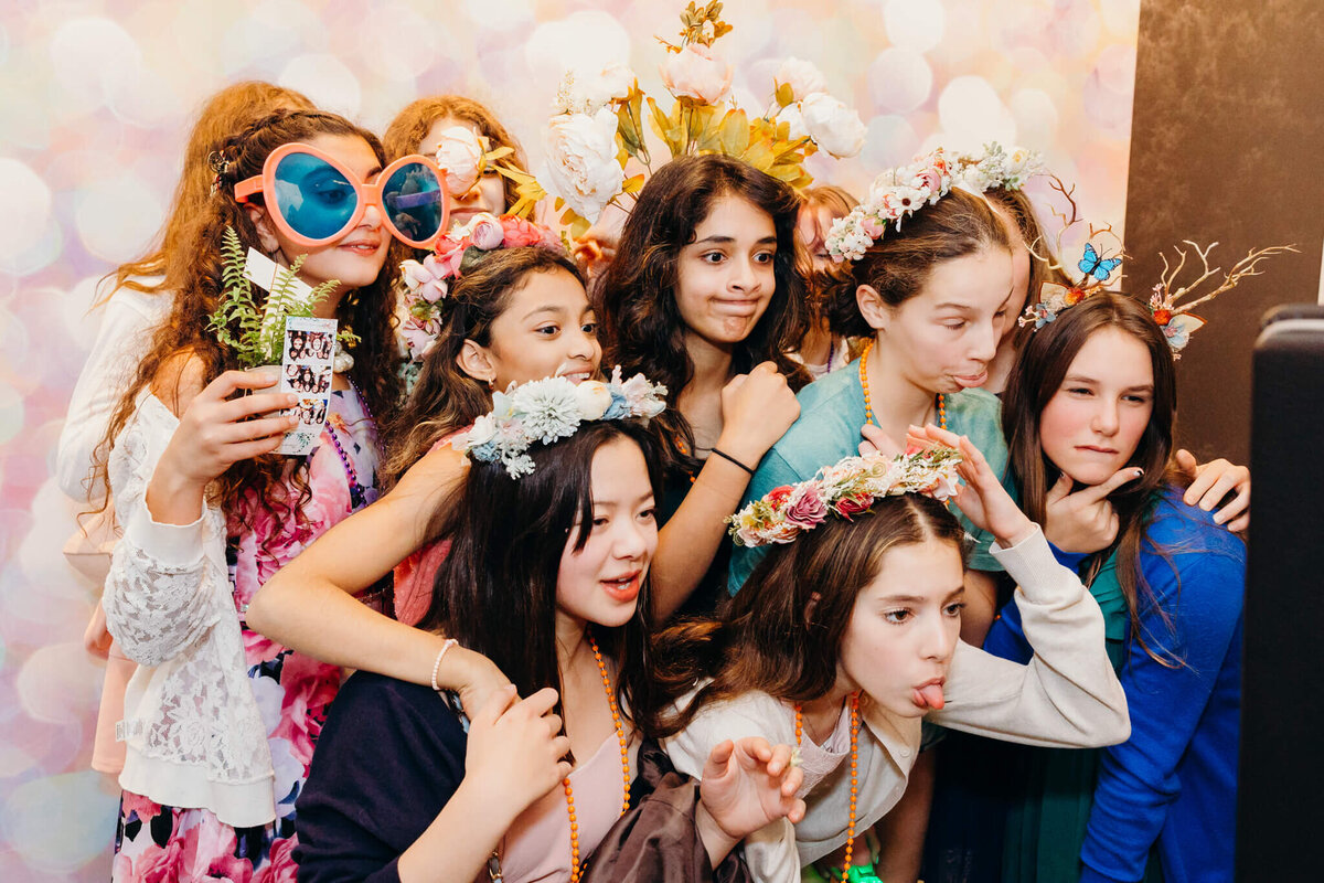 A group of girls make silly faces and use props in a photo booth for some Bellevue Bar and Bat Mitzvah Photography