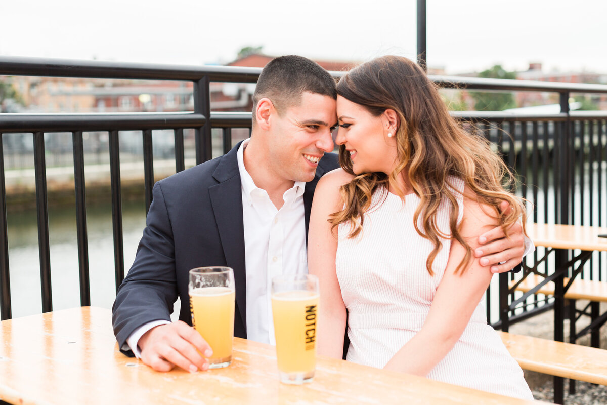 couple touching foreheads and drinking beer at brewery in Boston