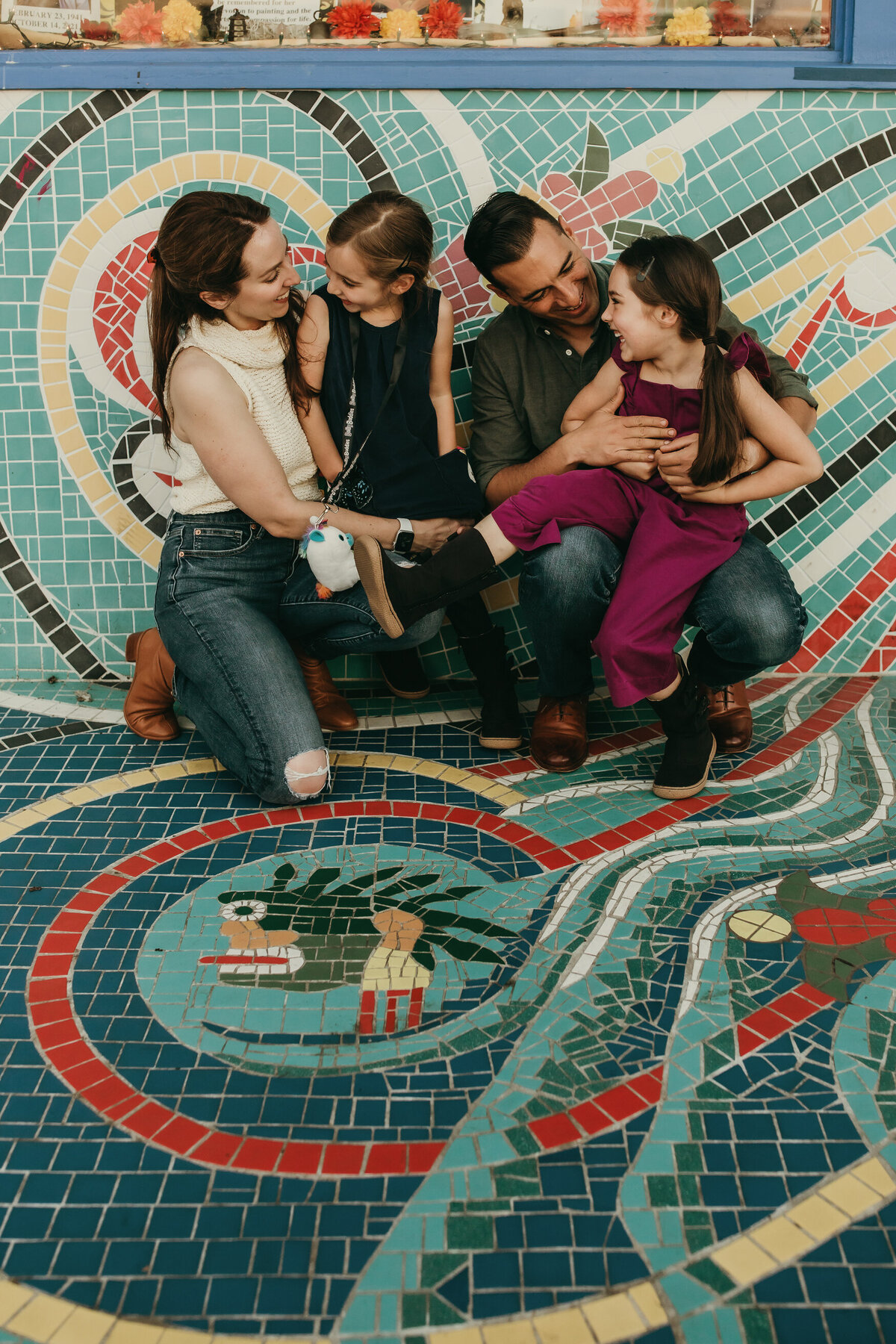 San Francisco family portrait in front of turquoise and red mosaic mural
