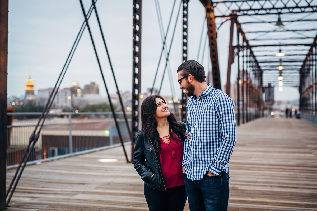 Winter engagement session in downtown San Antonio at the Hays Street Bridge. Fiancée in jacket and Fiancé in flannel shirt.