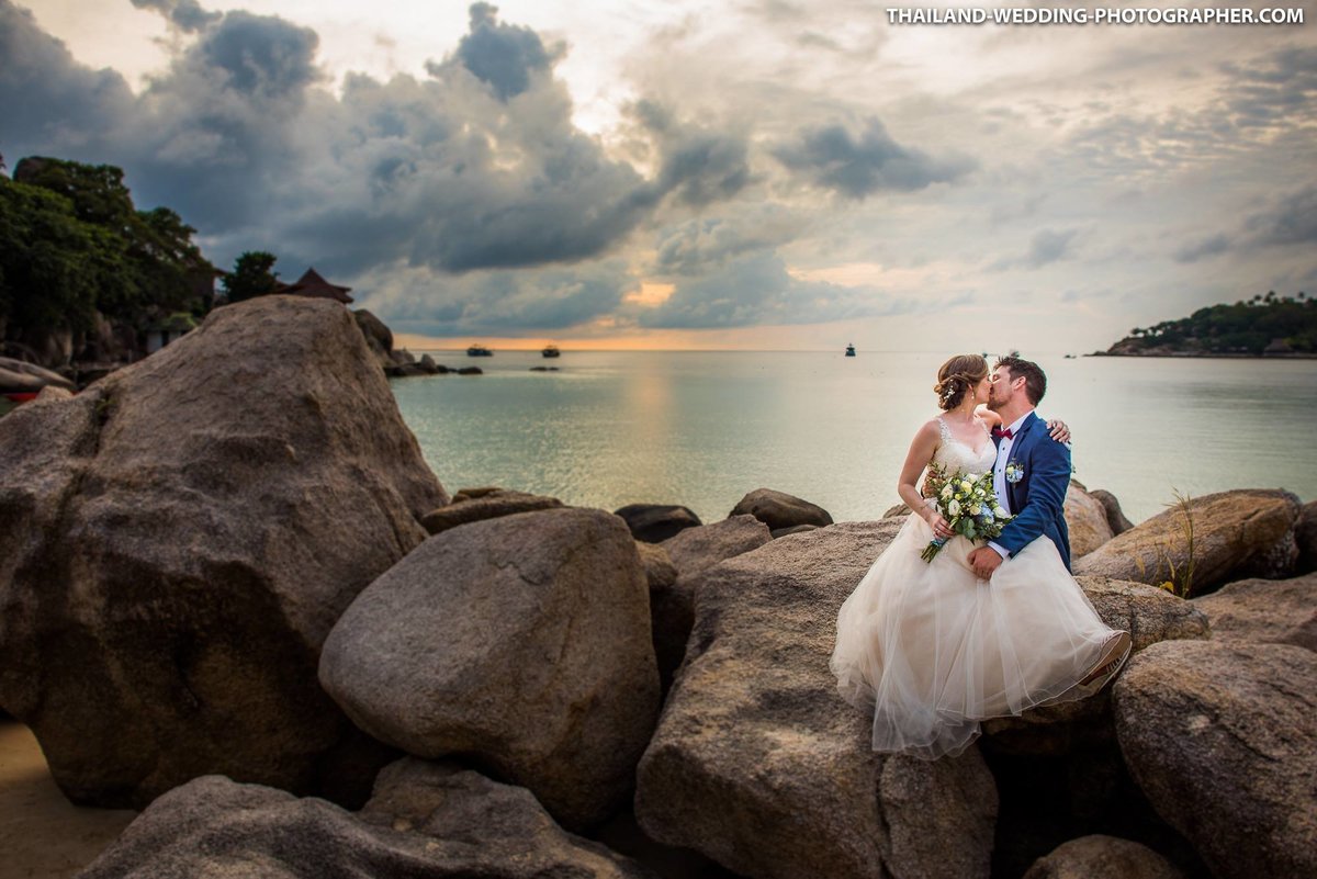 Bride and Groom sitting on rocks at Freedom Beach