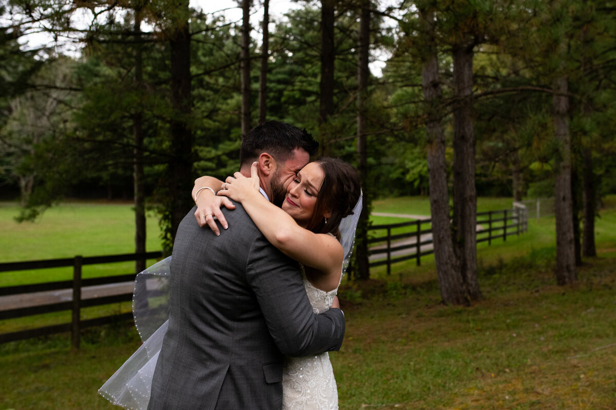 Bride and groom hold each other tightly during emotional first look before wedding