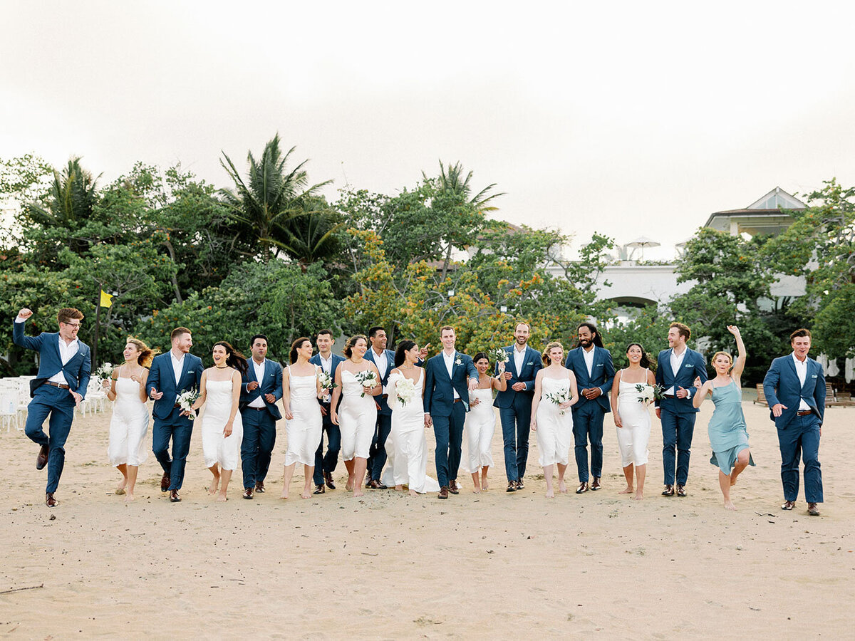 Outdoor destination beach wedding including wedding party , bride and groom