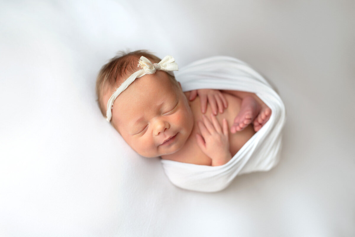 Newborn session of baby girl wearing a bow