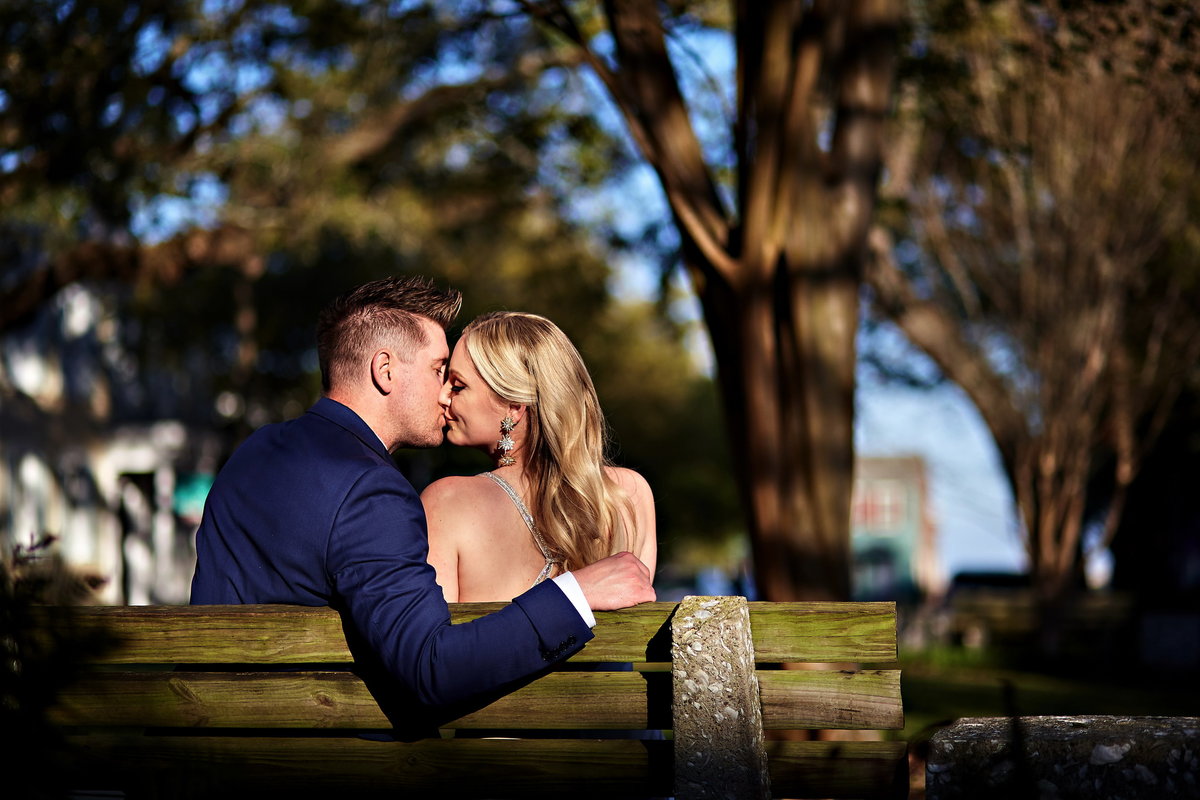 Savannah bride and groom kissing on a bench
